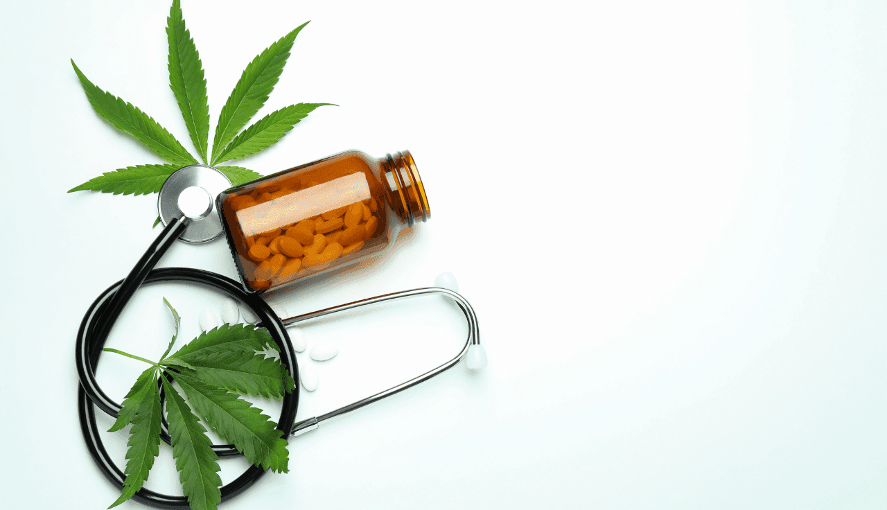 grünes Cannabis Blatt mit stetoskop und medikamenten